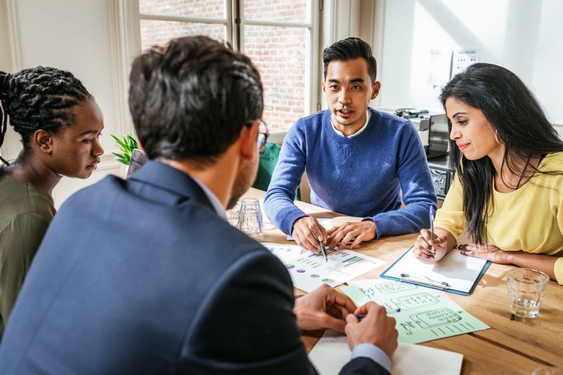 Multiracial group of young investors making financial plans.