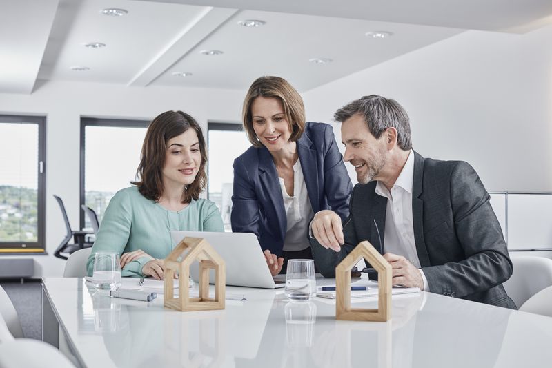 Business people having a meeting in office with laptop and architectural models.