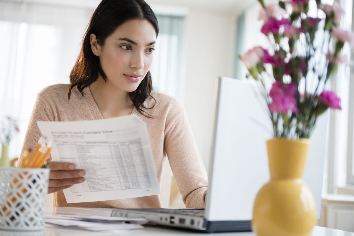 Young woman paying bills on her laptop.