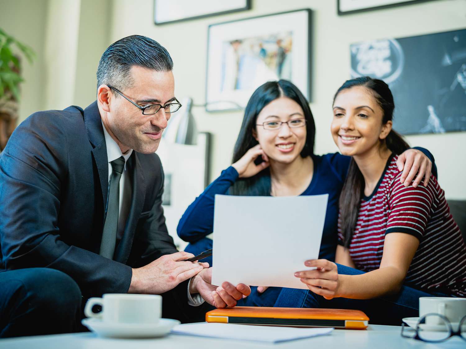 A financial advisor works with a young couple to explain how they can invest in an option of tax-efficient funds to reduce their tax liability.
