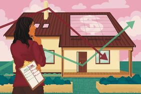 Person with long dark hair stands looking at a house with solar panels on it.
