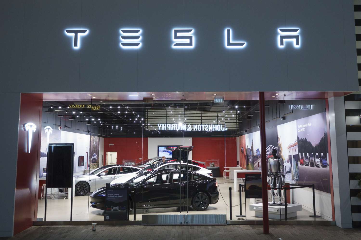 Tesla vehicles are seen in a showroom, with the company logo above the entrance.