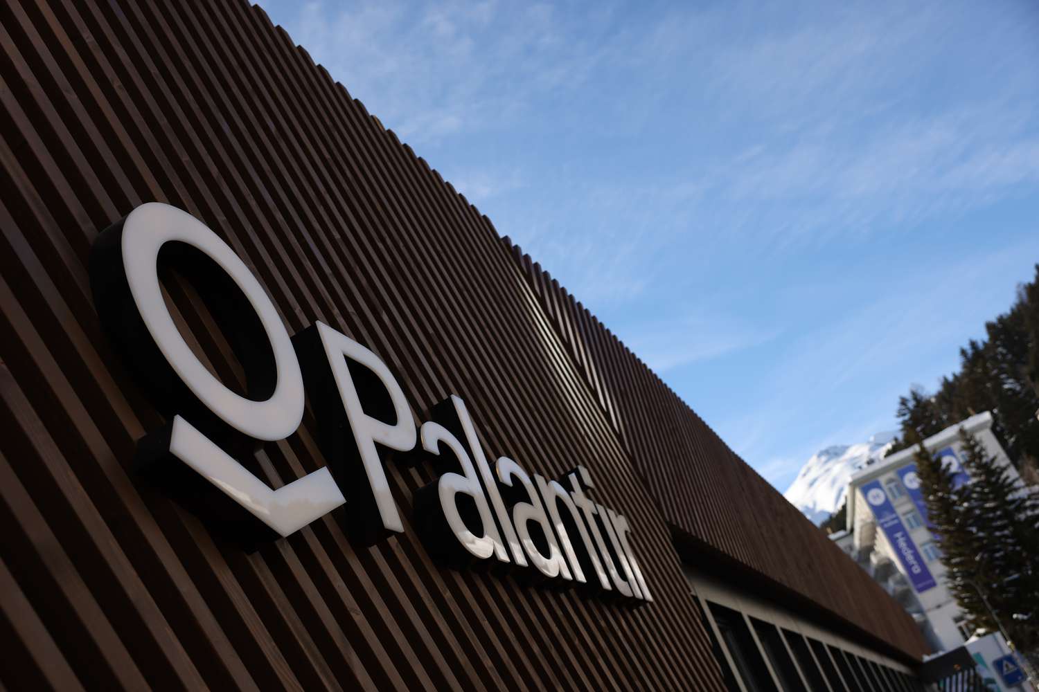 A sign displays the Palantir logo.