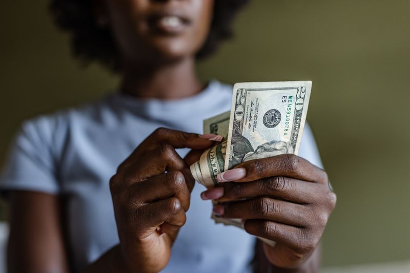 Woman counting $20 bills in her hand