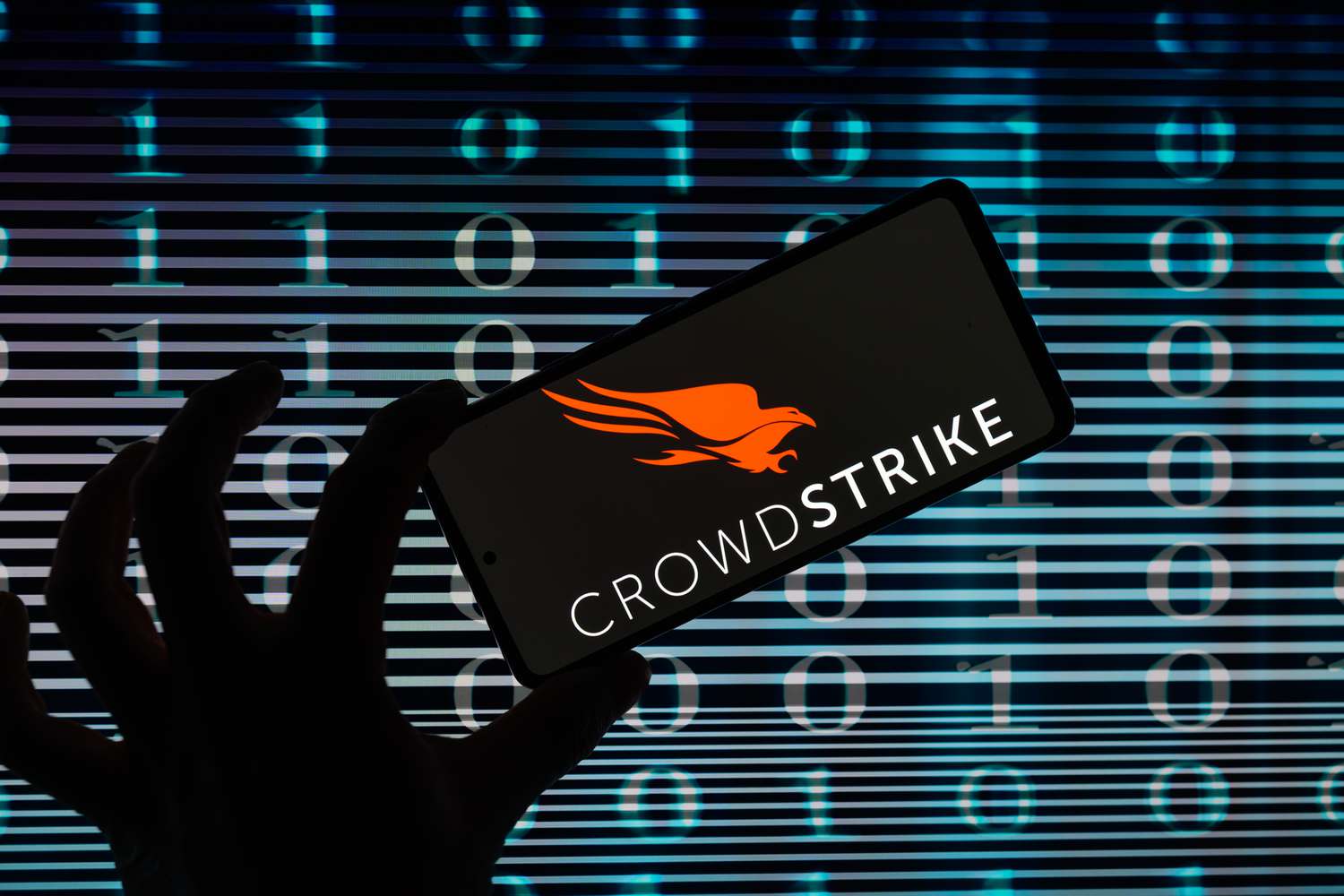 An illustration of a person holding a mobile device on which the Crowdstrike logo is shown. 