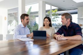 Home sellers talk to a realtor. 