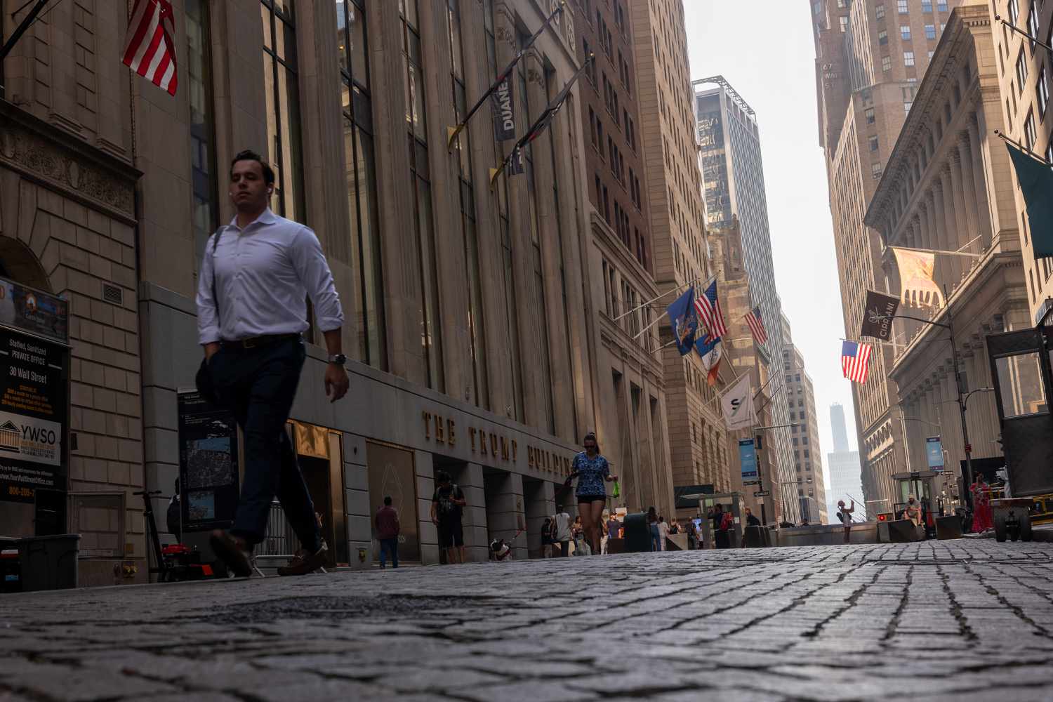 People walk outside of the New York Stock Exchange (NYSE)