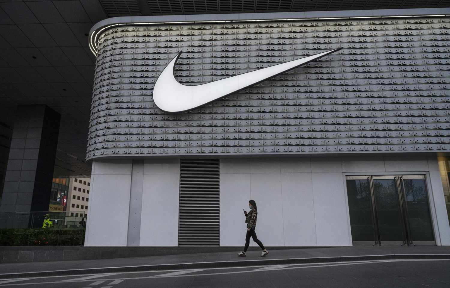 A woman walks outside a Nike store.