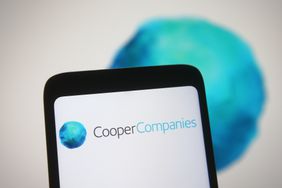 Cooper Companies logo is seen on a smartphone and a PC screen