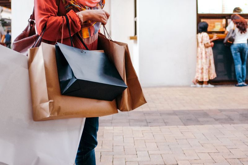 Midsection Of Woman Holding Shopping Bags