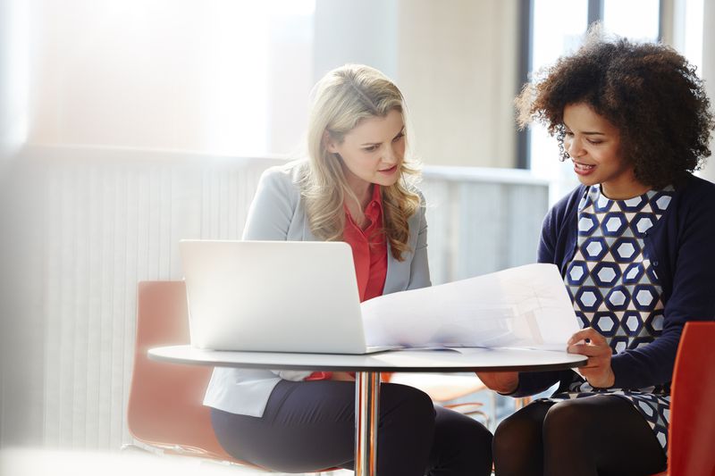 Two women review documents. 