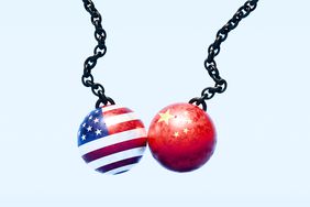An image of two wrecking balls, one draped in the American flag and the other in the Chinese flag, colliding mid-air. 