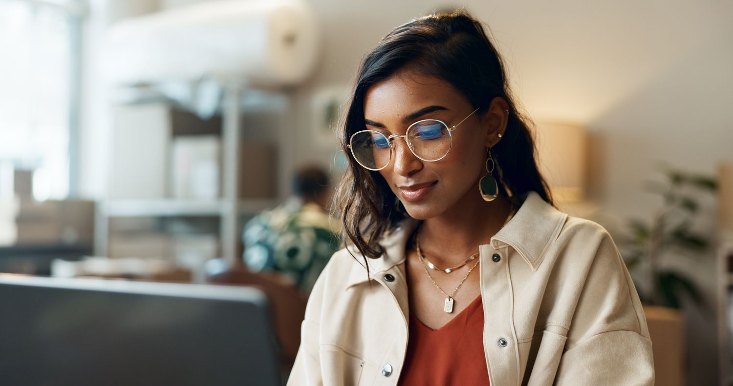 Woman looking at a laptop screen in an office setting. 