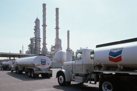 Three Chevron oil trucks line up outside the refinery in California