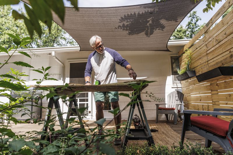A man cuts wood outside his home