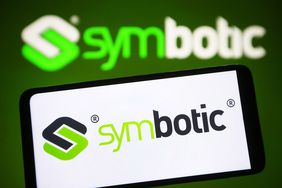 The green and black Symbotic logo is seen on a phone screen, with the logo also visible in the background.