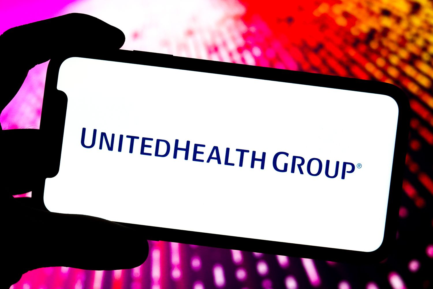 UnitedHealth Group logo is displayed on the screen of a smartphone