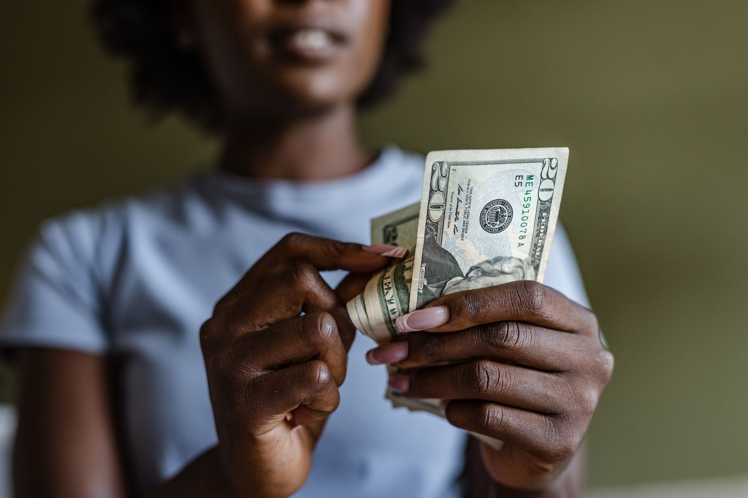 Woman counting $20 bills in her hand