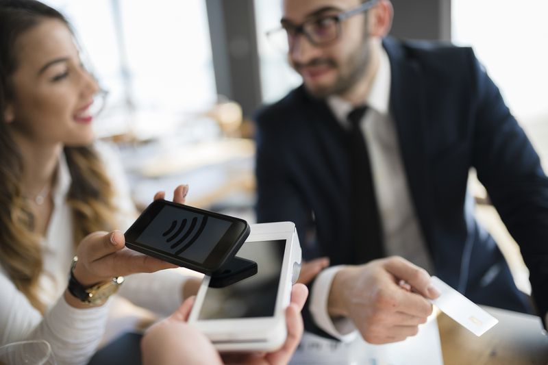 Business Executives Completing Transaction With Mobile Phone