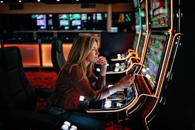 A woman plays machines at a casino.