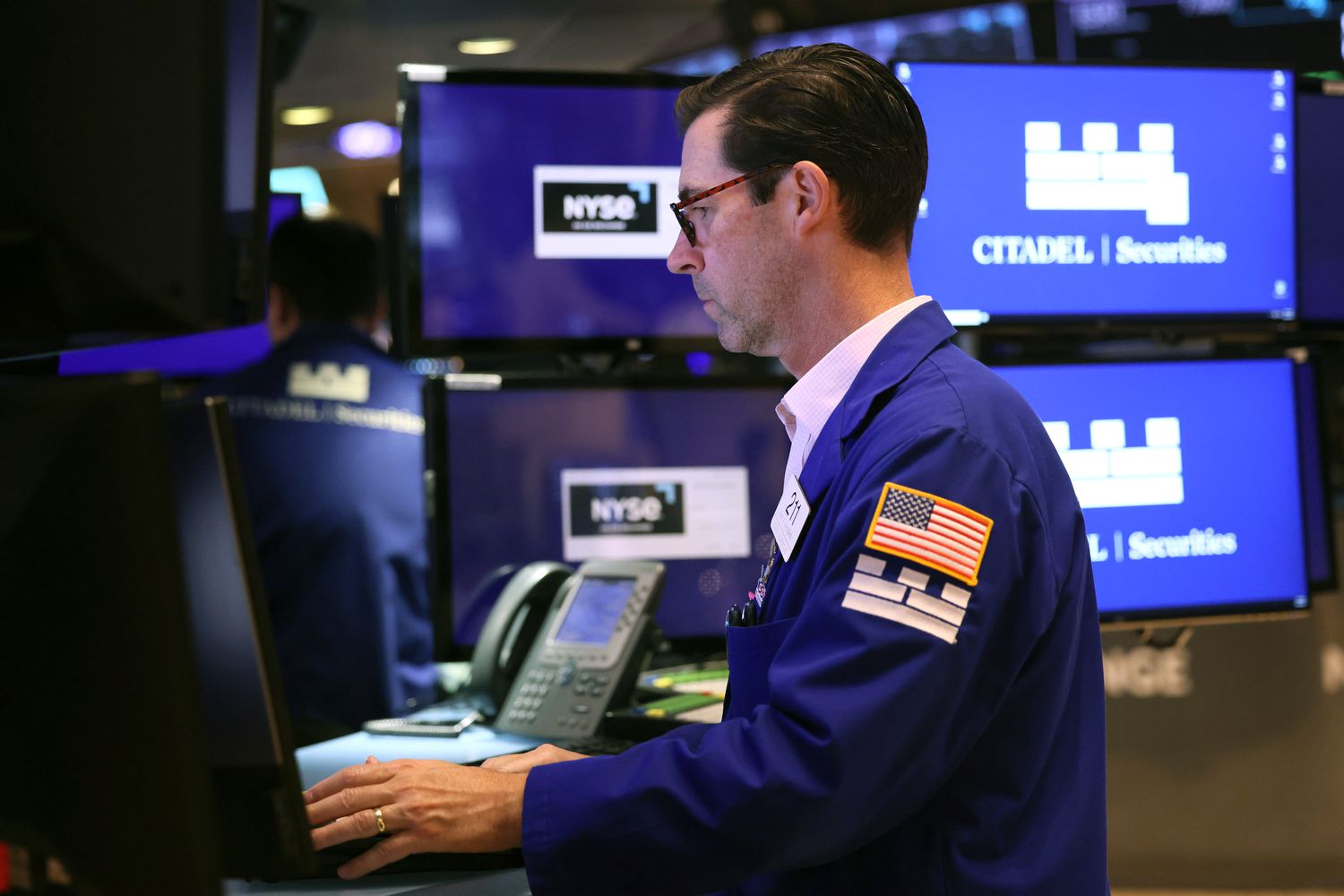 A trader faces a computer screen, working on the floor of the New York Stock Exchange.