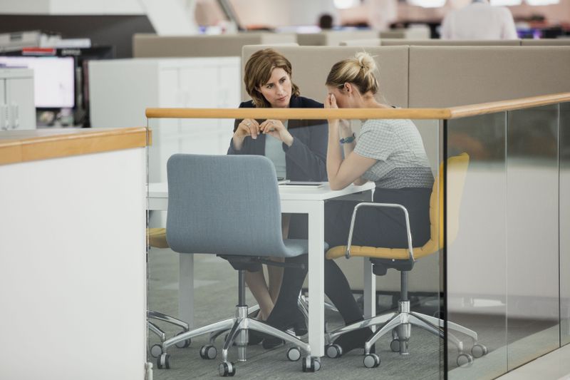 Two women in an office meeting in which one seems upset