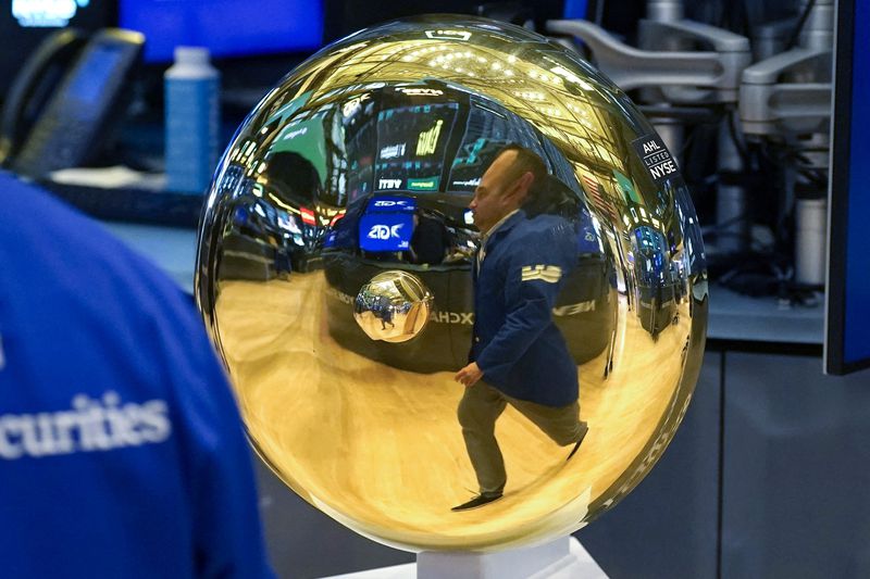 The reflection of a trader is shown in the bell on the floor of the New York Stock Exchange.