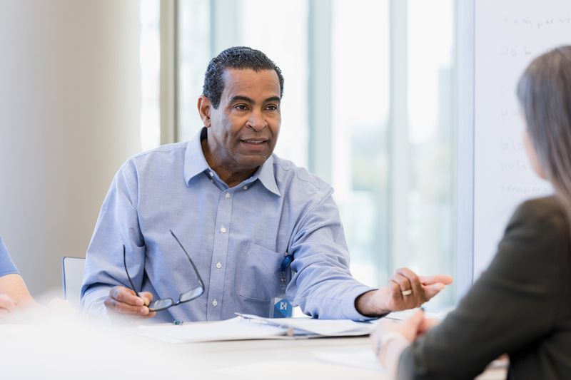 businessman gestures as he asks the financial advisor a question