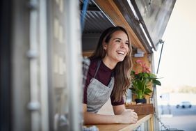 Smiling woman inside of food truck.