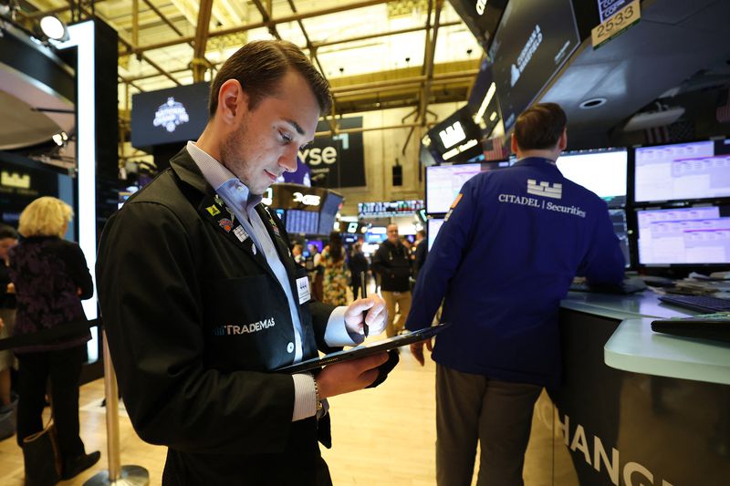 A trader looks at a tablet on the floor of the New York Stock Exchange