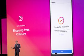 Adam Mosseri, head of Instagram, speaks on stage in front of a bright pink screen displaying a phone with an Instagram Shopping order confirmation.