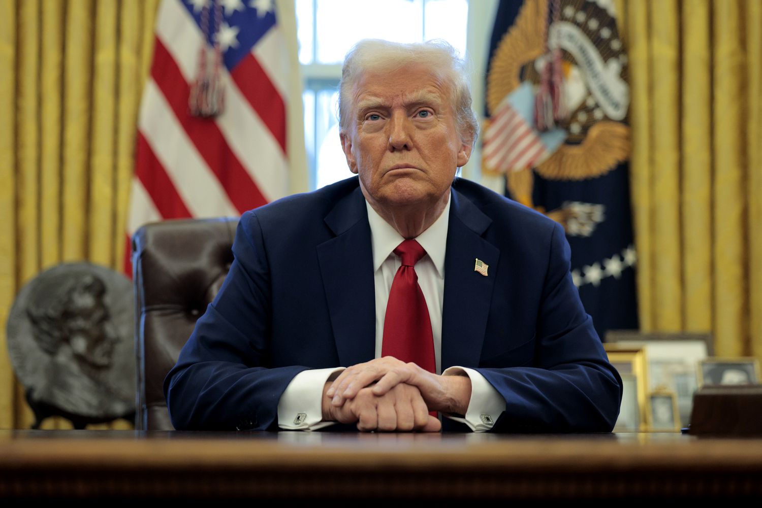 President Donald Trump sits at the Resolute Desk.