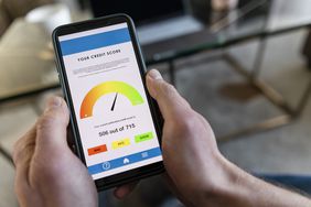 A person holding the phone with a bad credit score displayed while looking for ways to improve the credit score fast.