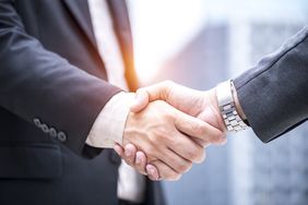 A businessman shaking hand with business partner investment for success plan.