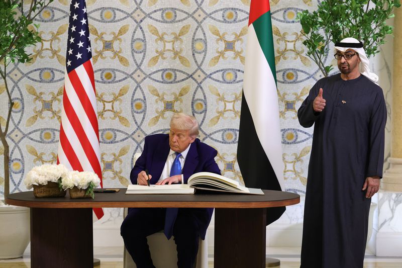 U.S. President Donald J. Trump signs the guestbook as UAE President Sheikh Mohamed bin Zayed Al Nahyan looks on.