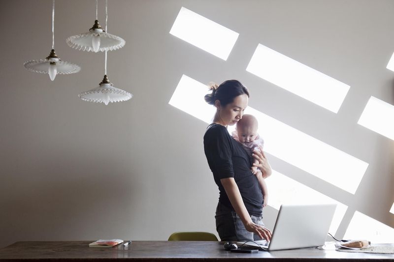 New mother starting a business from home, holding baby