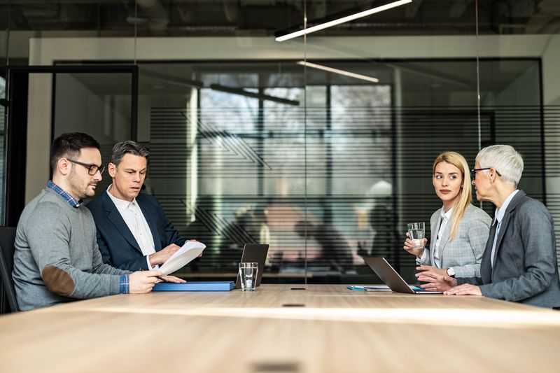 Young couple and their lawyers talking about the divorce during a meeting in the office. 