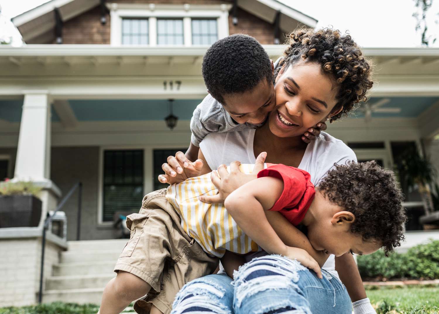 A homeowner plays with children near their front porch