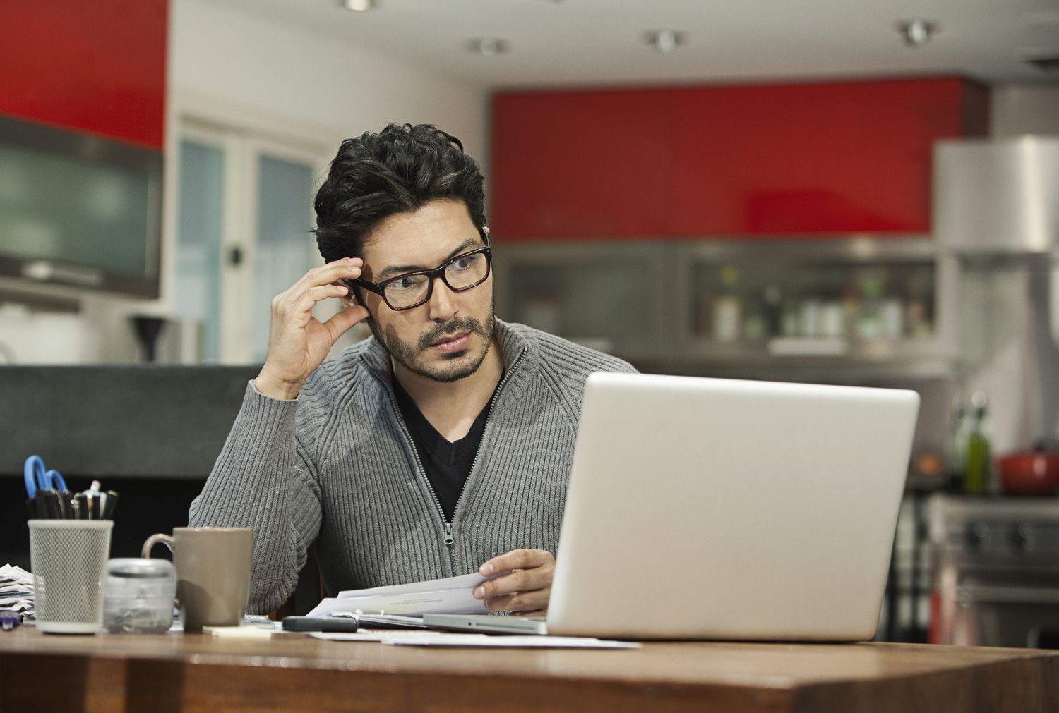 A man looking worriedly at a computer