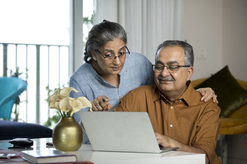 Senior couple looking together at laptop