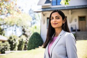 Real estate agent in front of home.