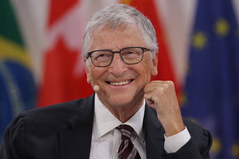 Bill Gates smiling while on a panel.
