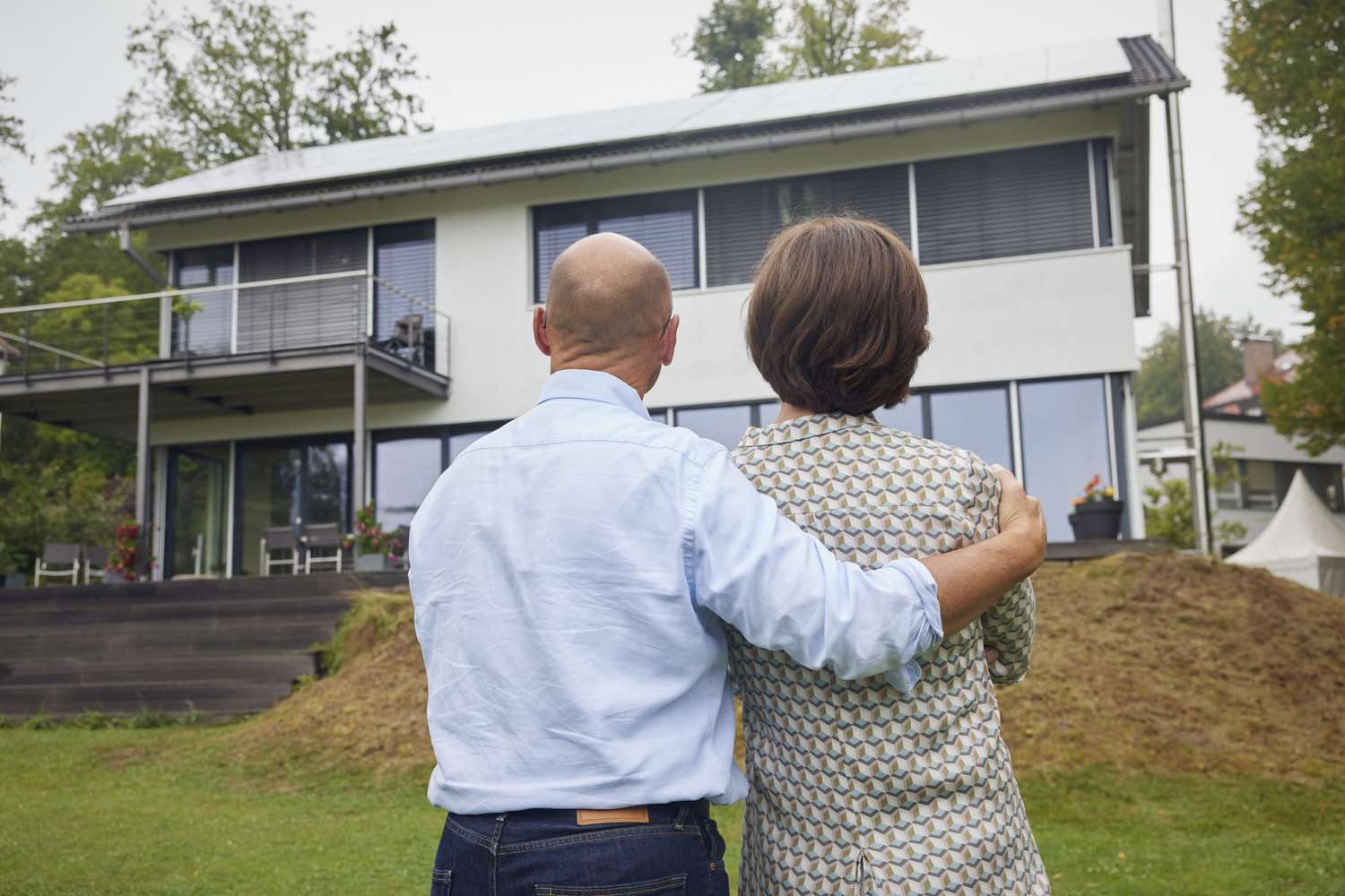 A couple standing together in front of a house
