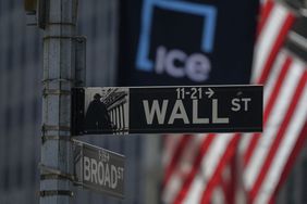 A street sign for Wall Street shown in front of the New York Stock Exchange