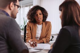 Couple consulting with a female financial manager at the bank