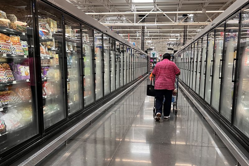 A customer walks down an aisle at Walmart. 