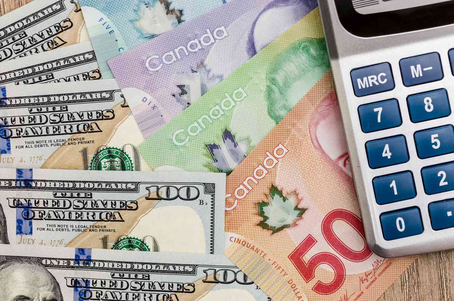 A calculator alongside US and Canadian dollars