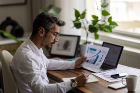 A business person working on a financial accounting project at a desk..