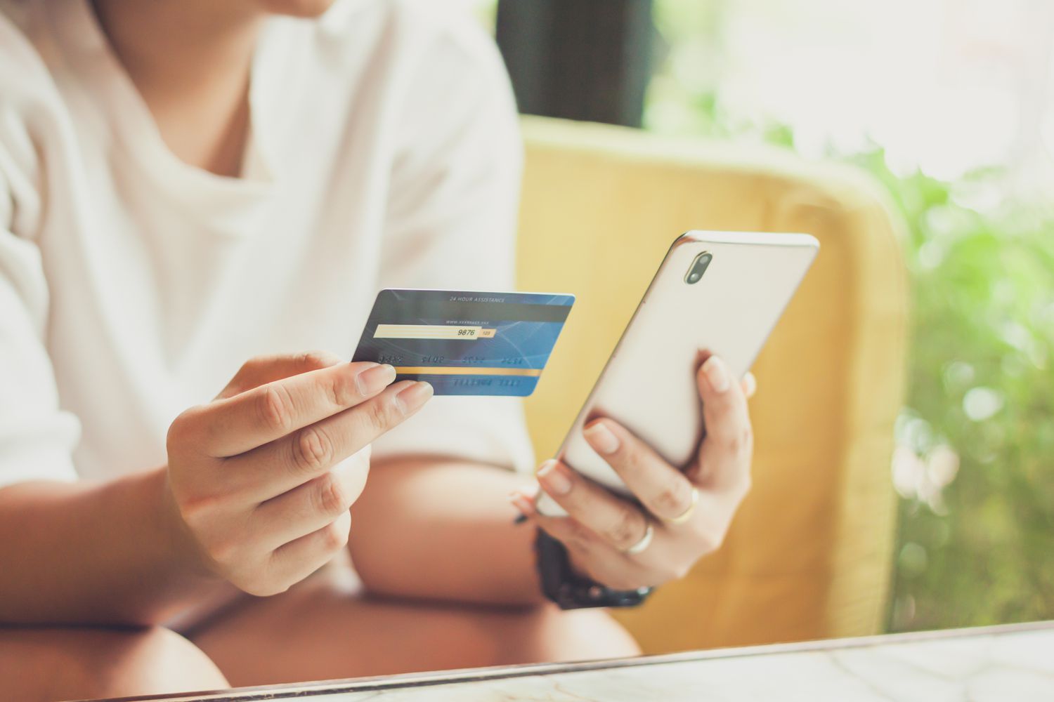 Woman hand using smart phone and holding credit card for shopping payment online, or for business, finance, and payment concepts.