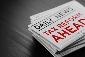 Tax Reform Concept Newspaper Pile On Black Wood Surface